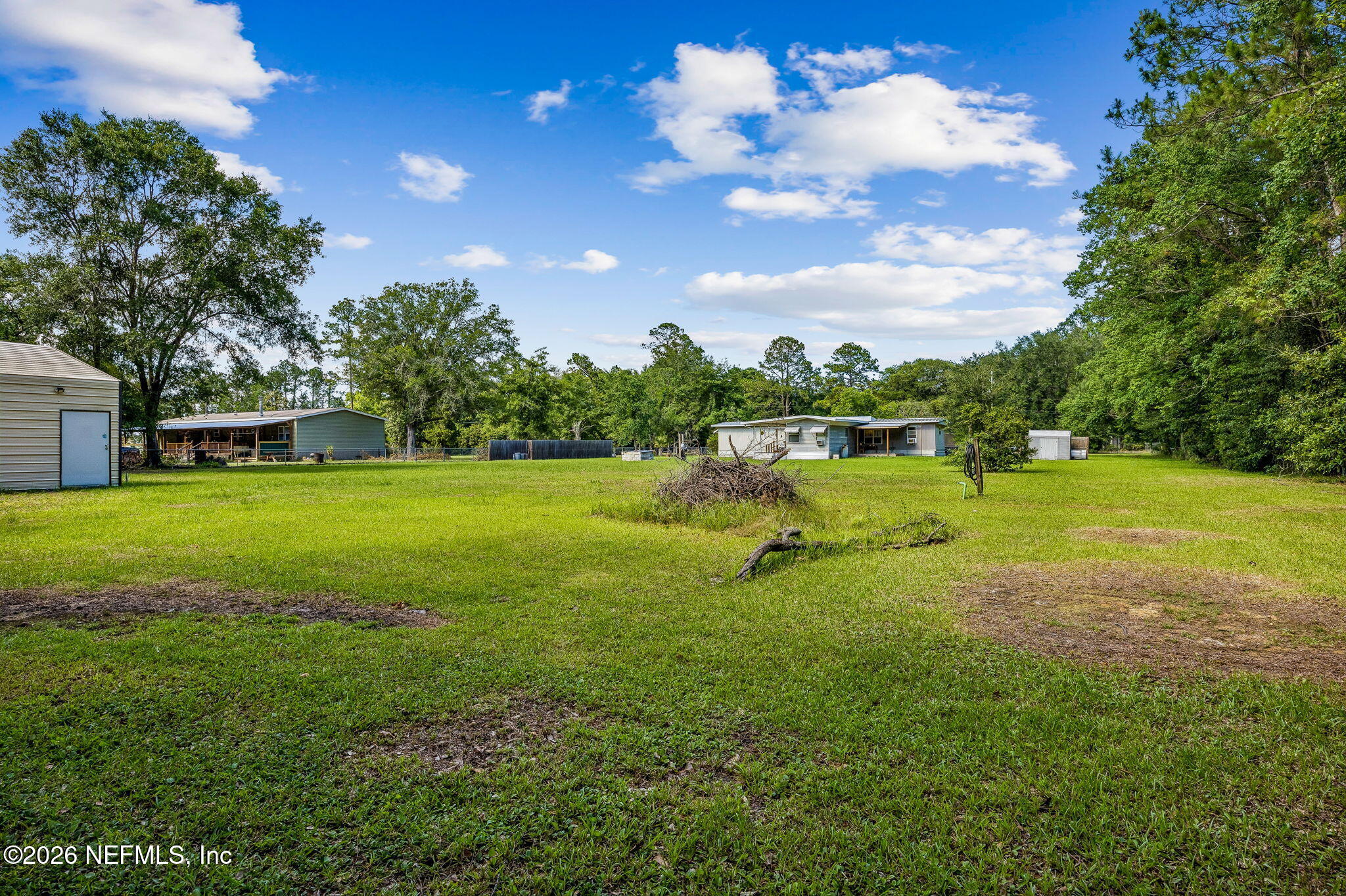 15690 Sears Road Jacksonville, FL 32218 - Photo 23 of 27 a swimming pool with lots of green space and trees in the back