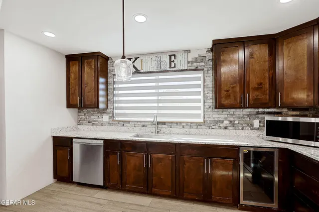 an empty room with wooden floor chandelier fan and windows
