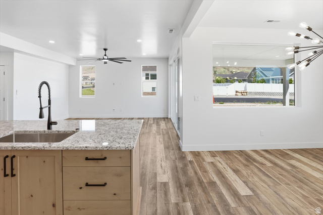 1315 West 3200 South, Unit 17 Perry, UT 84302 - Photo 16 of 58 Kitchen island featuring a stainless steel undermount sink and a matte black gooseneck faucet