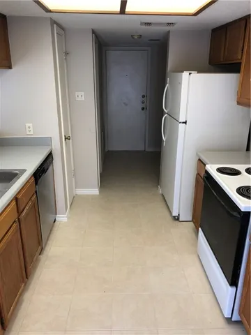 a view of a storage and utility room with refrigerator