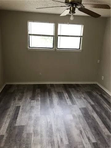 a view of a room with wooden floor and a window