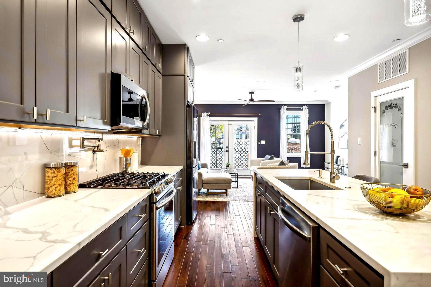 1213 Holbrook Street Northeast, Unit 1 Washington, DC 20002 - Photo 6 of 26 a kitchen with stainless steel appliances granite countertop a sink stove a refrigerator and cabinets
