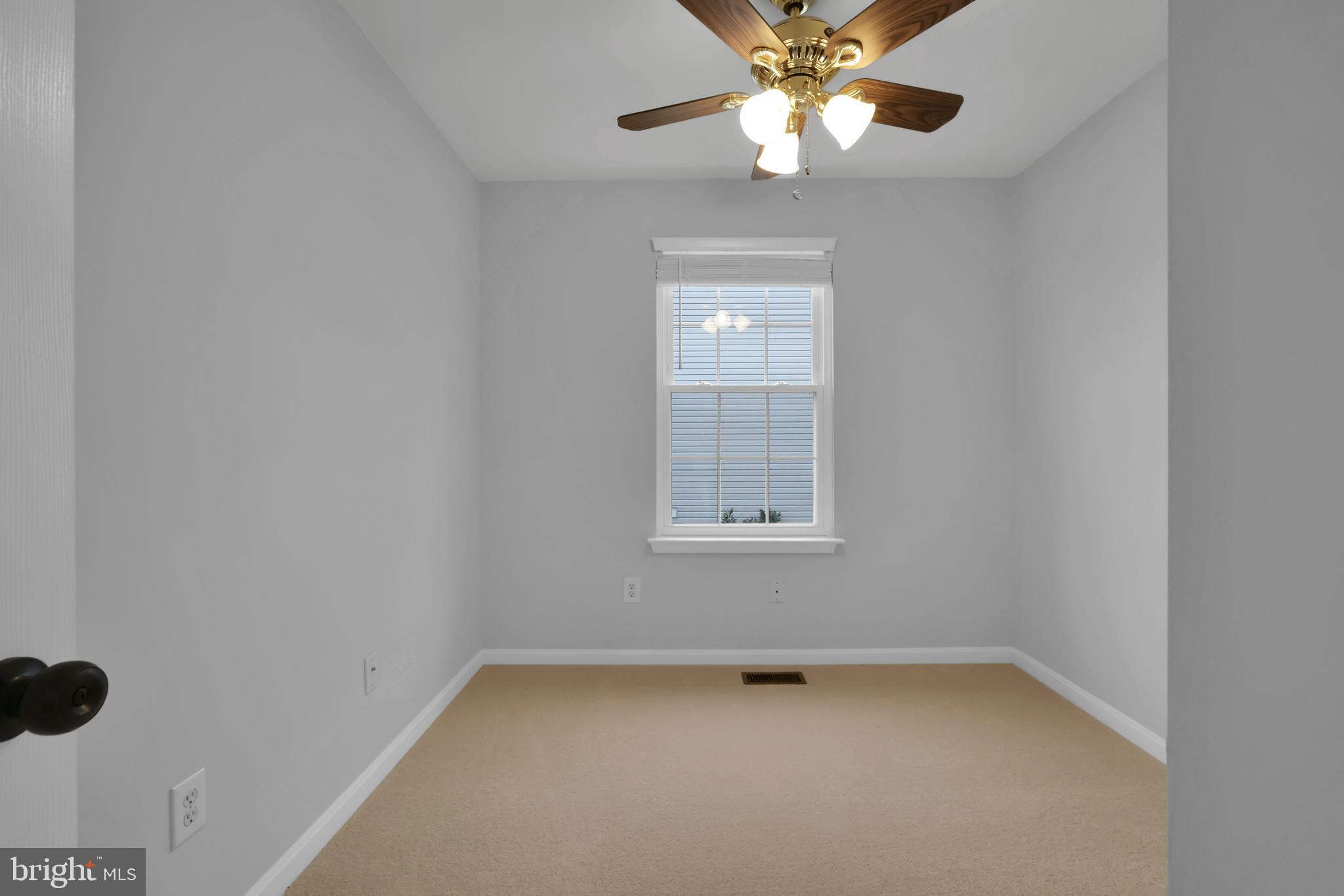 126 Myrtle Avenue Severn, MD 21144 - Photo 34 of 52 an empty room with a chandelier fan and windows