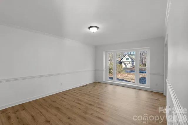 an empty room with wooden floor and painted walls