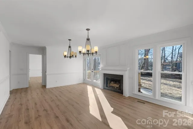 a view of empty room with wooden floor and fireplace