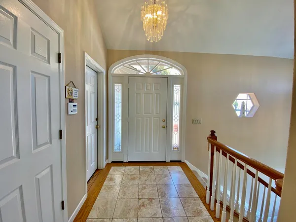 a view of a hallway with windows and chandelier