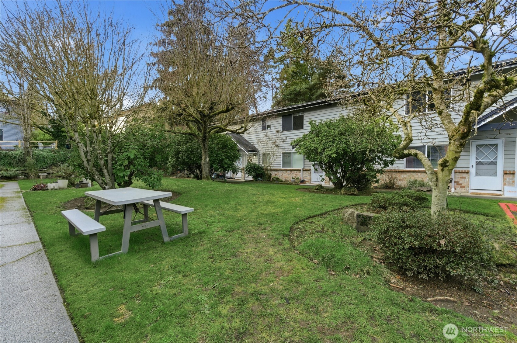 7909 218th Street Southwest, Unit 6 Edmonds, WA 98026 - Photo 3 of 27 a view of a backyard with table and chairs and a tree