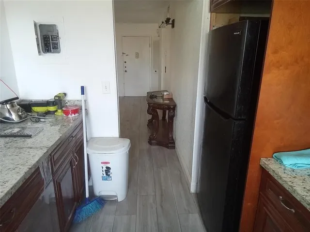 a kitchen with stainless steel appliances granite countertop refrigerator stove and wooden floor