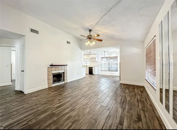 a view of empty room with wooden floor and fireplace