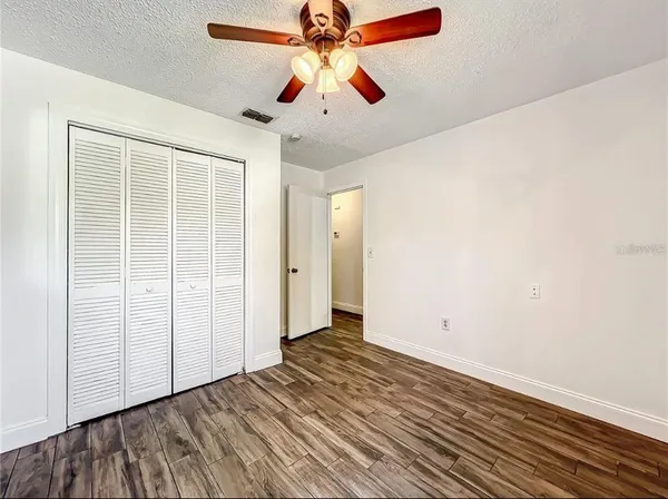 an empty room with fan and windows