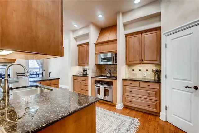 a kitchen with stainless steel appliances granite countertop a sink stove and refrigerator