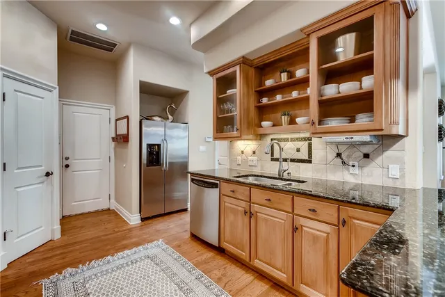 a kitchen with stainless steel appliances granite countertop a refrigerator and a sink