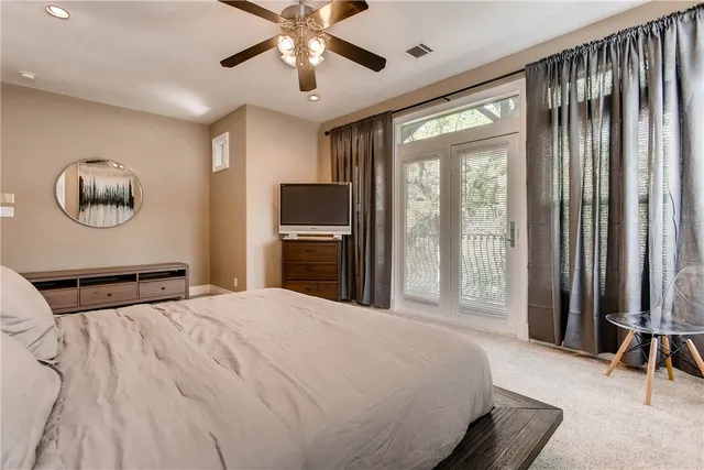 a bedroom with a large bed and a chandelier