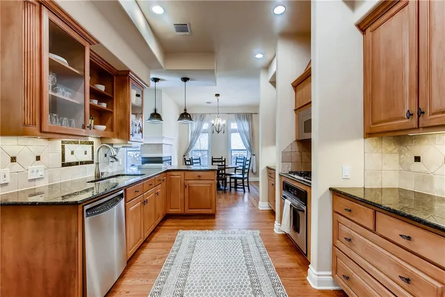a kitchen with stainless steel appliances granite countertop sink stove and cabinets