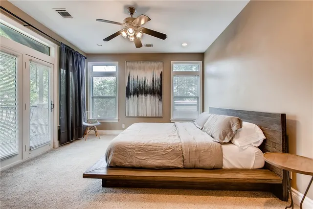a spacious bedroom with a large bed and a chandelier