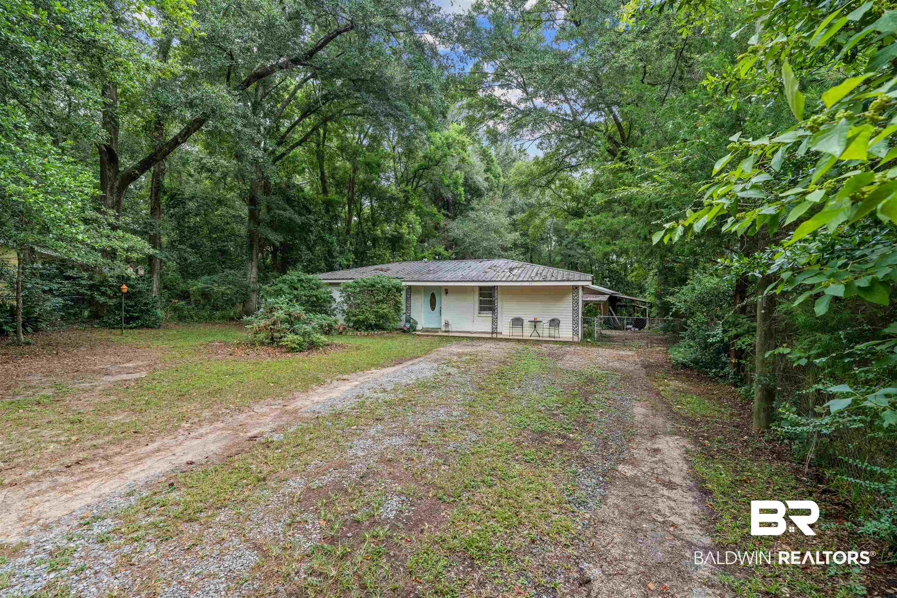 922 Dauphine Circle Daphne, AL 36526 - Photo 12 of 29 View of yard featuring dirt driveway, covered porch, and a view of trees