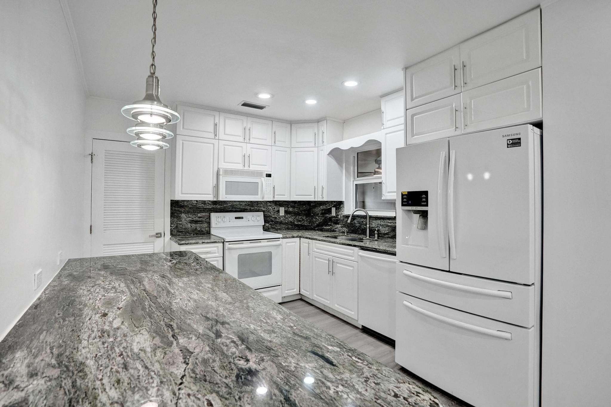 7341 Meridian Street Miramar, FL 33023 - Photo 27 of 74 a kitchen with white cabinets and white appliances