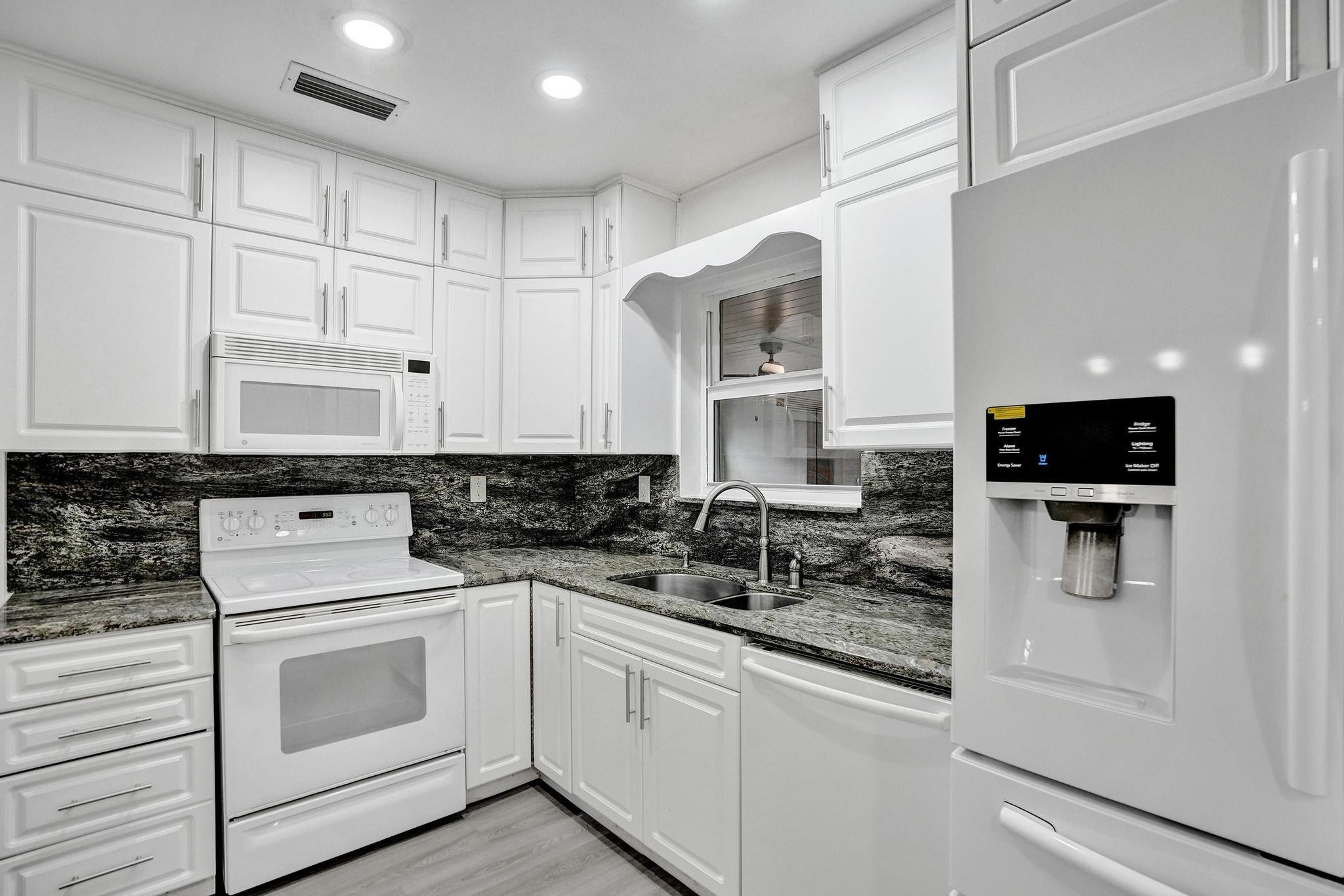 7341 Meridian Street Miramar, FL 33023 - Photo 28 of 74 a kitchen with white cabinets and white appliances