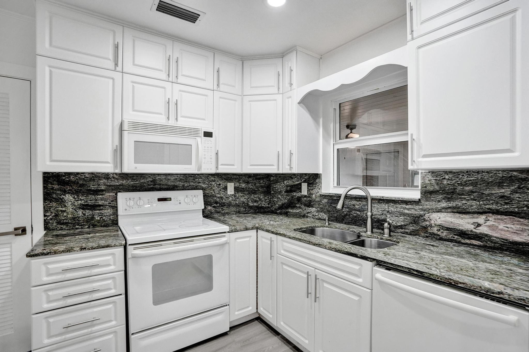7341 Meridian Street Miramar, FL 33023 - Photo 29 of 74 a kitchen with granite countertop white cabinets and white appliances