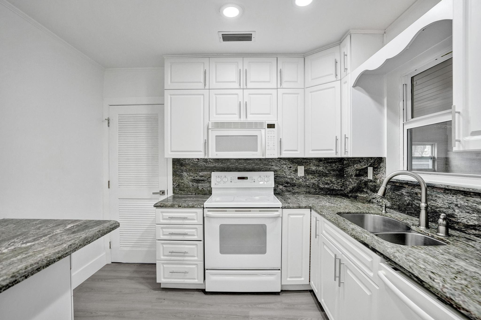 7341 Meridian Street Miramar, FL 33023 - Photo 30 of 74 a kitchen with granite countertop white cabinets and white appliances