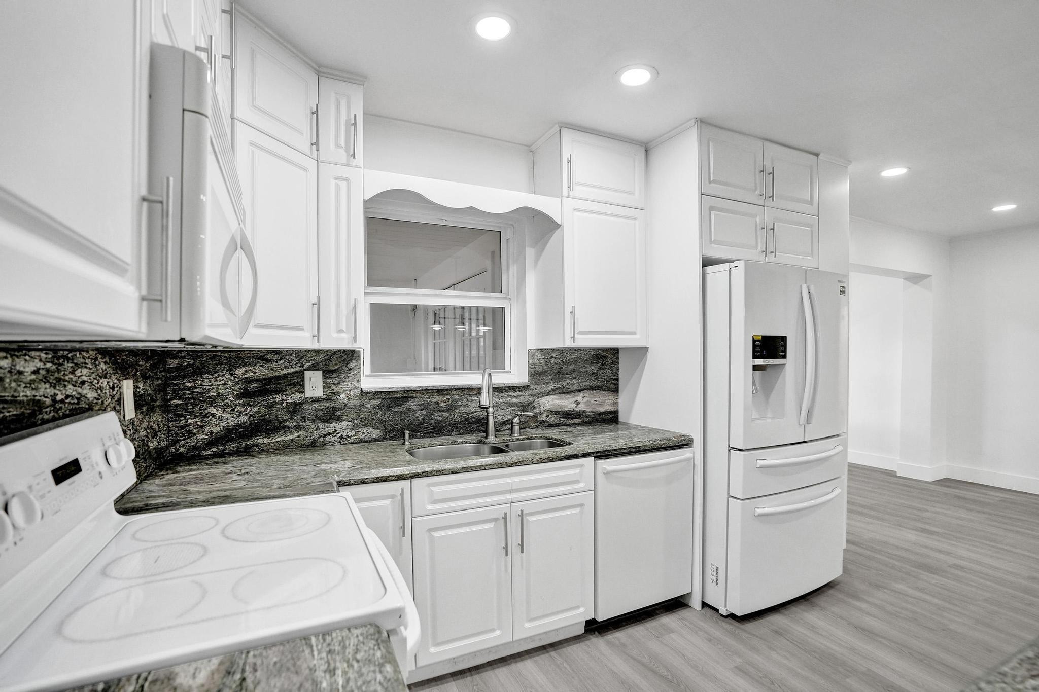7341 Meridian Street Miramar, FL 33023 - Photo 32 of 74 a kitchen with white cabinets and refrigerator