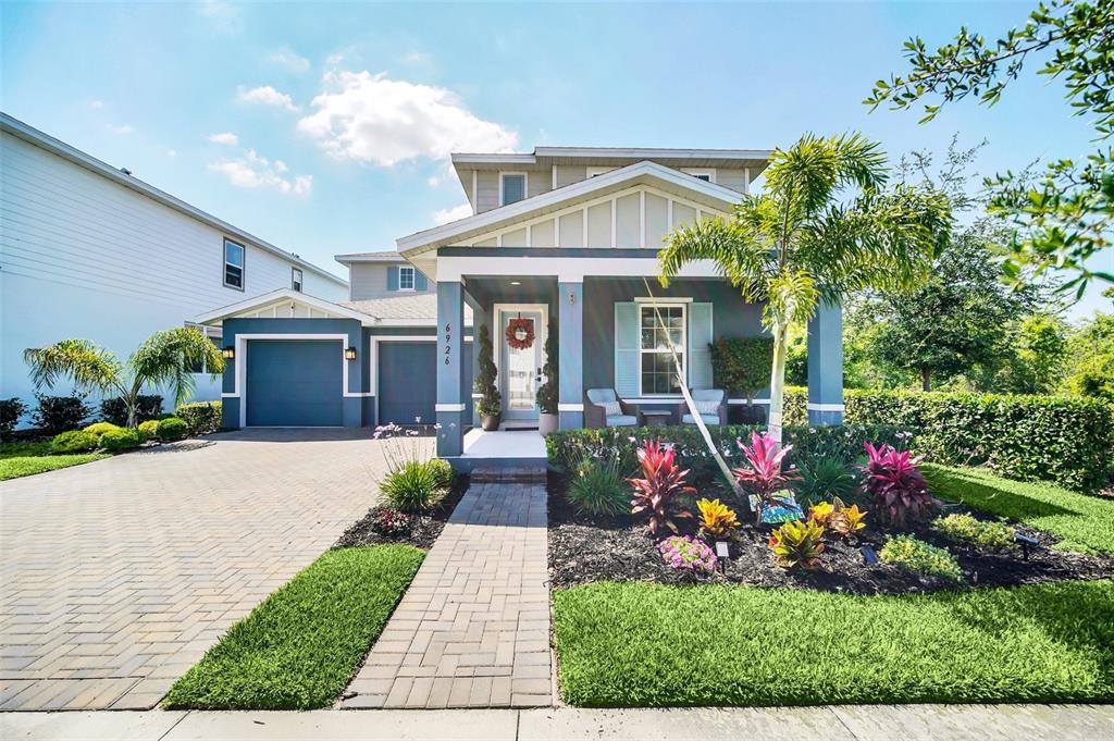 a front view of a house with a porch and a garden