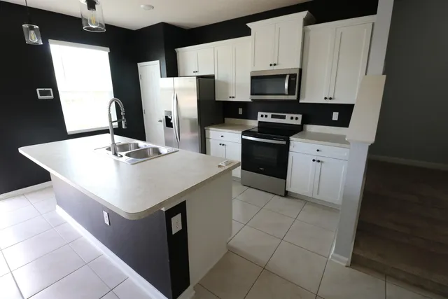 a kitchen with stainless steel appliances a stove refrigerator sink and microwave