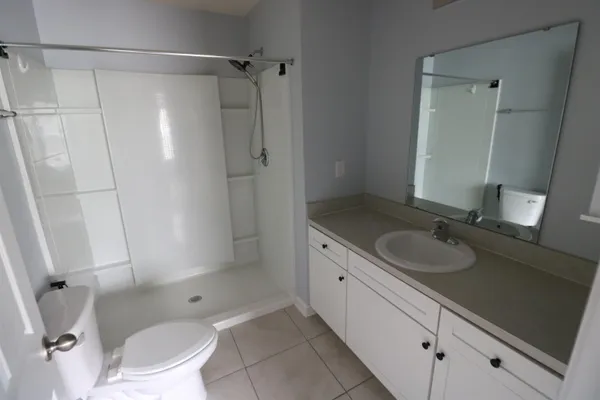 a bathroom with a granite countertop sink toilet and shower