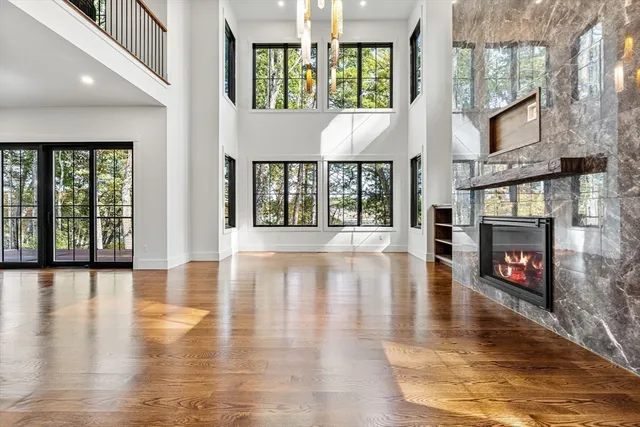a large kitchen with kitchen island granite countertop wooden floors and a view of living room