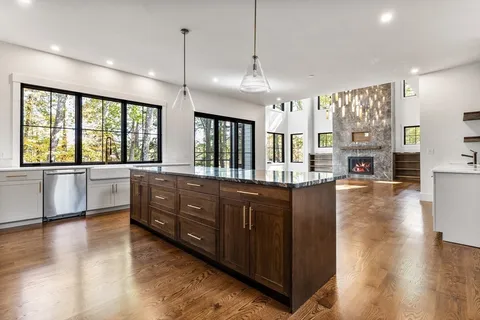 a large kitchen with a large counter top a sink a counter space and stainless steel appliances