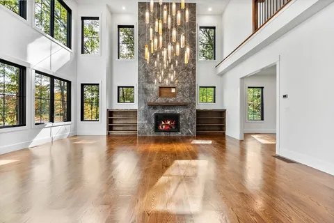 a view of an entryway with wooden floor fireplace and windows