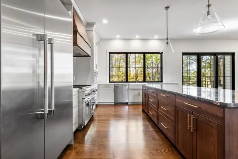a large kitchen with a large window and stainless steel appliances