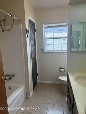 a bathroom with a tub a sink and a window