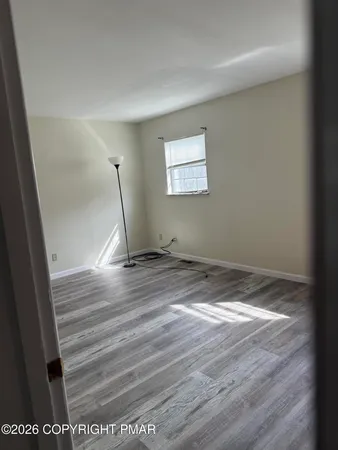 a view of empty room with wooden floor