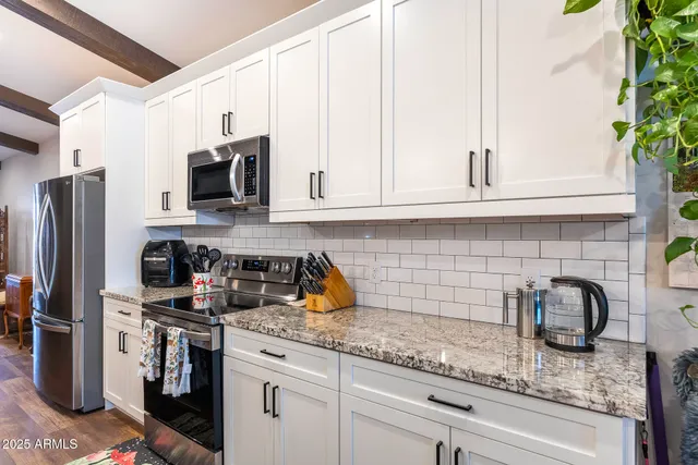 a kitchen with stainless steel appliances granite countertop a refrigerator a stove a sink and dishwasher