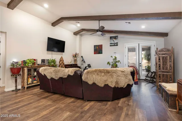 a spacious bedroom with a bed and a flat screen tv