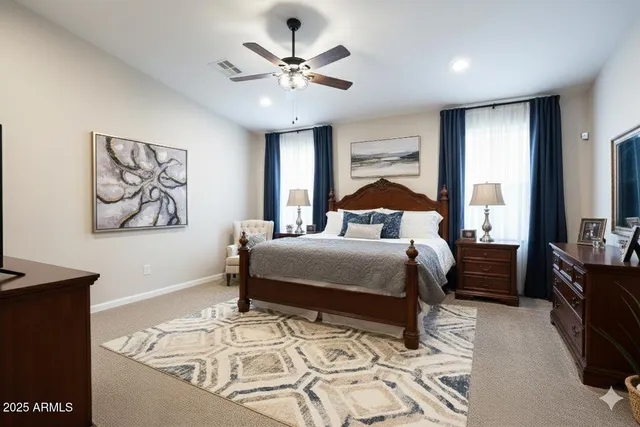 a bedroom with a large bed and a chandelier