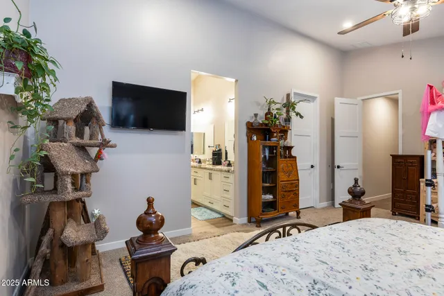 a bedroom with furniture a flat screen tv and a potted plant