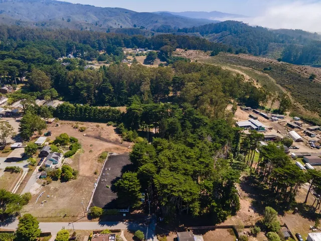 an aerial view of mountains residential house and green space