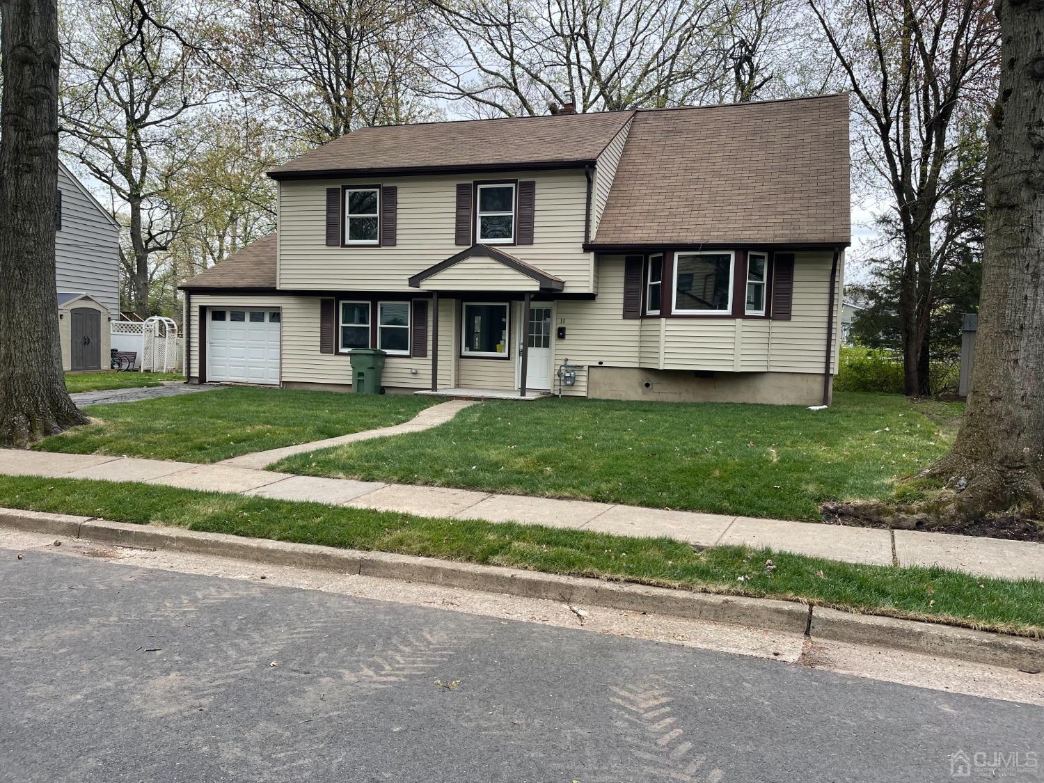 11 Hill Road Edison, NJ 08817 - Photo 1 of 24 a front view of a house with a garden and trees