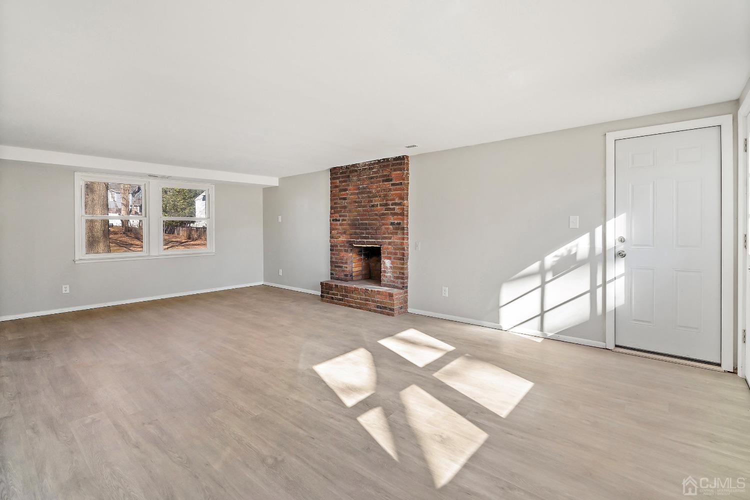 11 Hill Road Edison, NJ 08817 - Photo 4 of 24 a view of empty room with wooden floor and fireplace