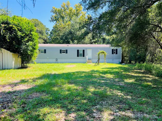 a swimming pool with a lawn chairs and plants