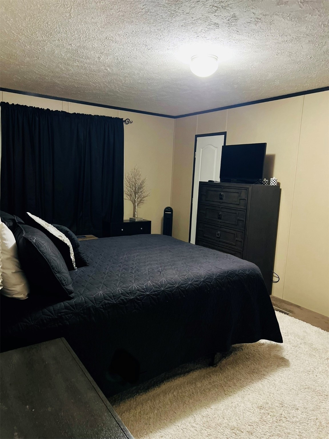73 County Road 3703 Splendora, TX 77372 - Photo 11 of 14 a bedroom with a bed and a dresser
