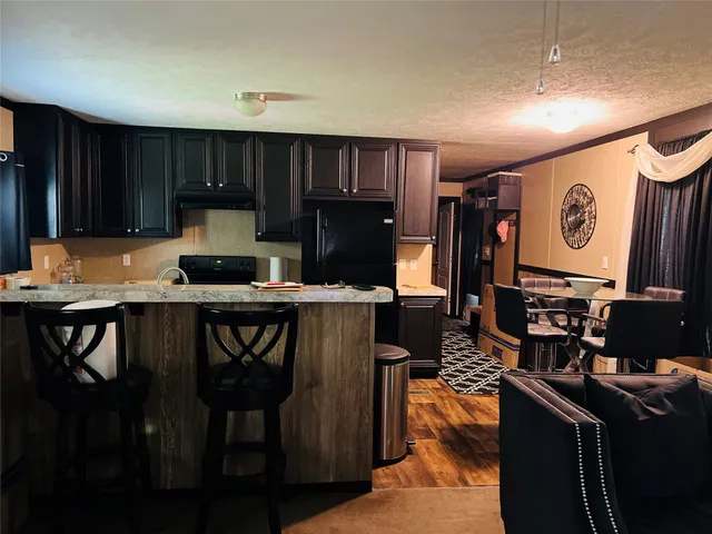 a kitchen with a table chairs refrigerator and cabinets