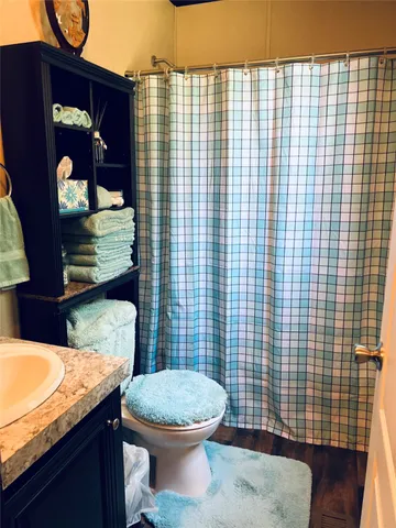 a bathroom with a granite countertop toilet and sink