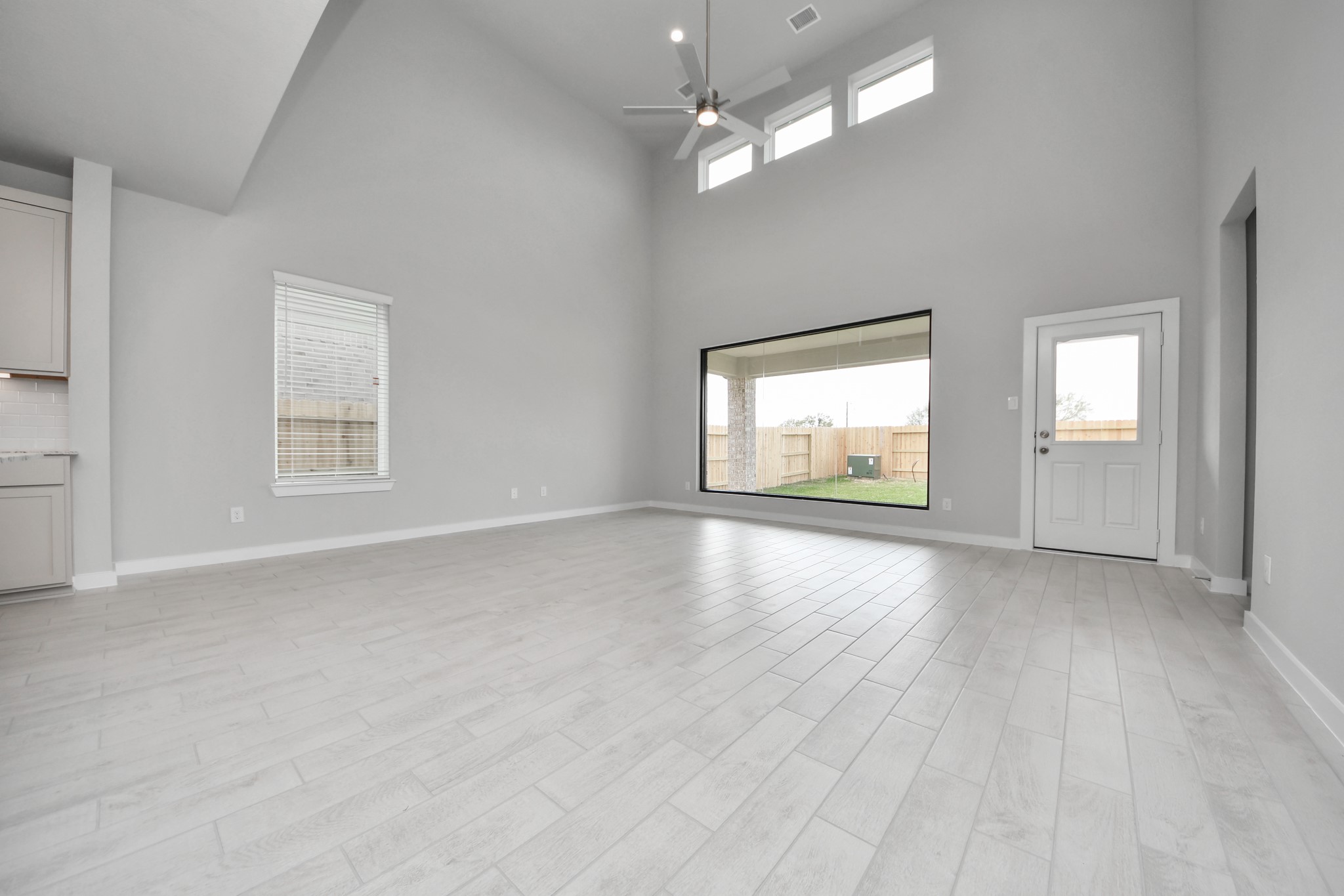 11122 Tulip Rdg Trail Houston, TX 77044 - Photo 14 of 34 an empty room with wooden floor chandelier fan and windows