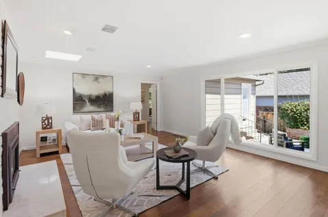 a living room with furniture a flat screen tv and a large window