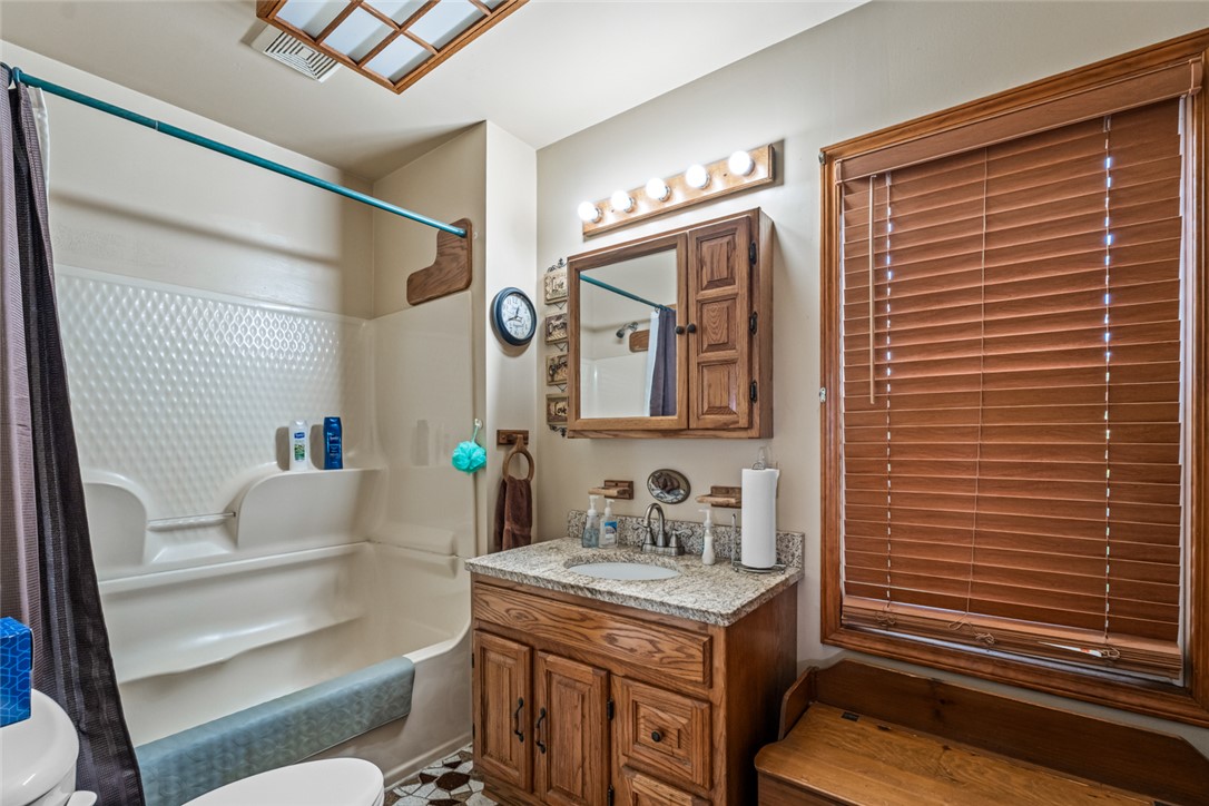 7404 Grubbs-Rex Road Arcanum, OH 45304 - Photo 13 of 40 This bathroom features a functional vanity with ample storage and a window with natural light.
