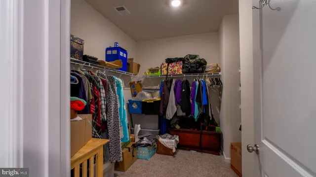 a view of walk in closet with clothes