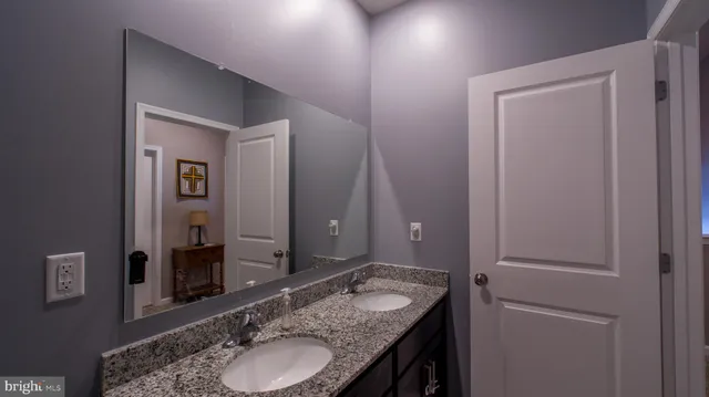 a bathroom with a granite countertop sink and a mirror